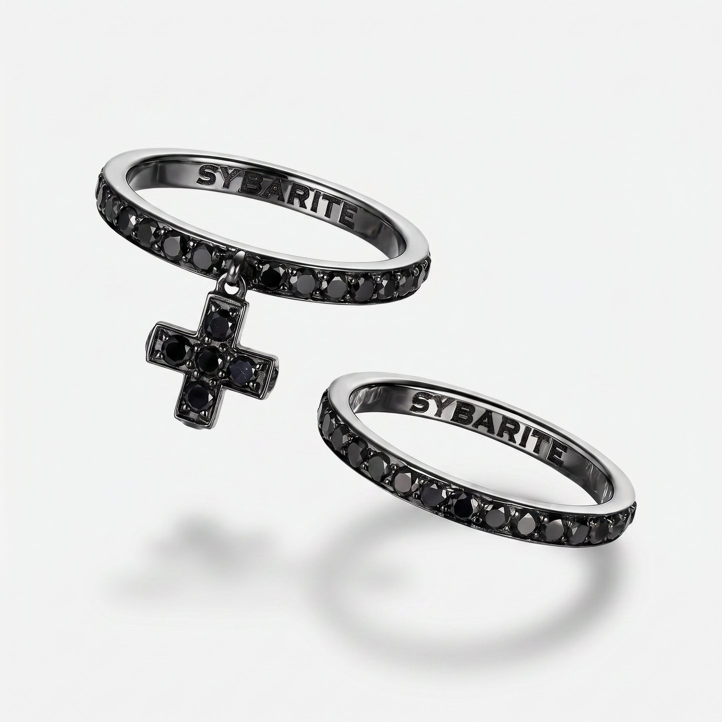 Blackened 18k gold rings set with black diamonds by Sybarite Jewellery, luxury designer stackable rings with cross charm, modern gothic fine jewellery