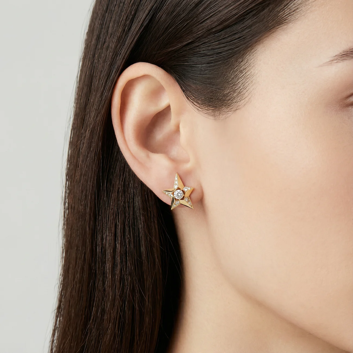Diamond star stud earrings in 18k gold on ear, minimal luxury jewellery styling