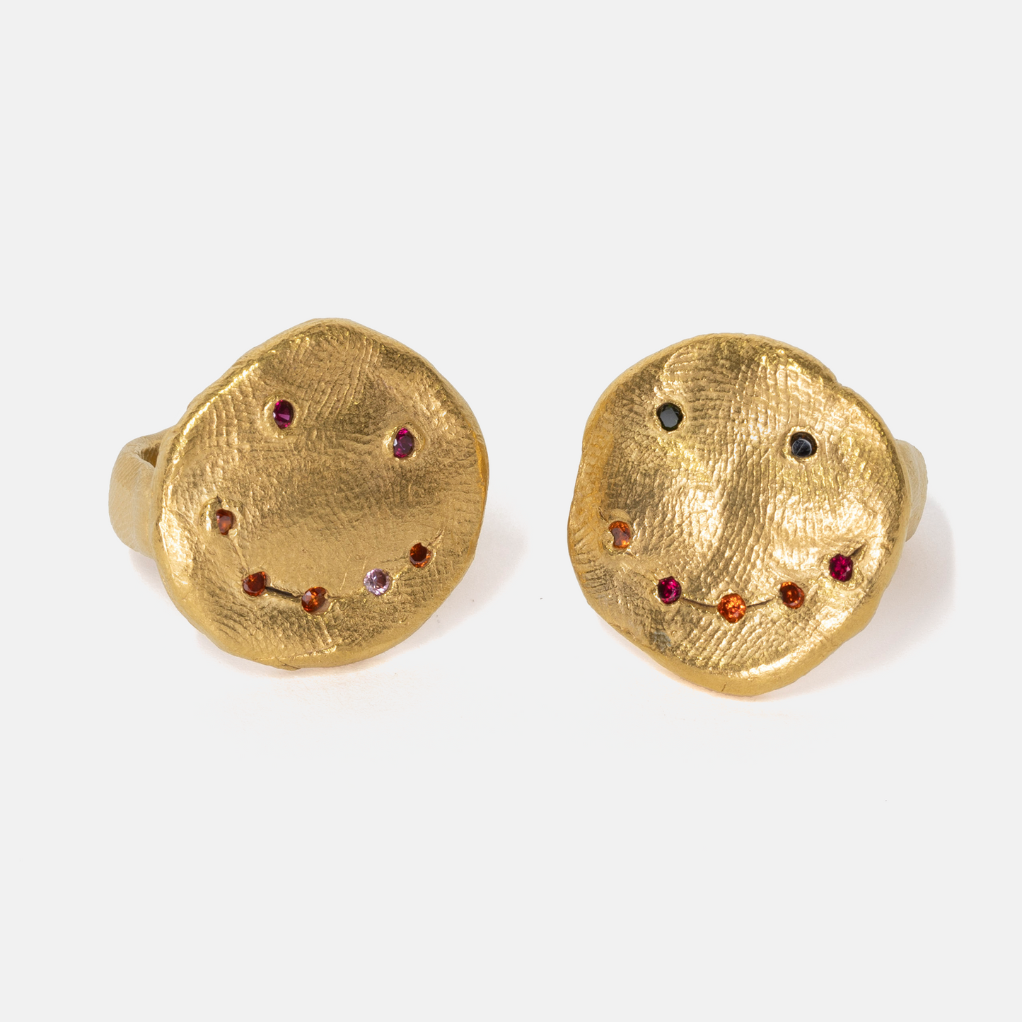 Pair of gold earrings with embedded gemstones on a white background