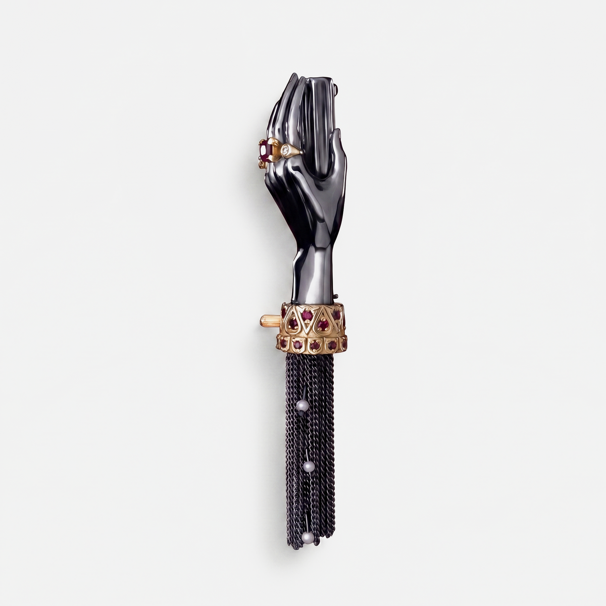 Black hand brooch with gold cuff, ruby stones and chain tassel, unique designer jewellery piece