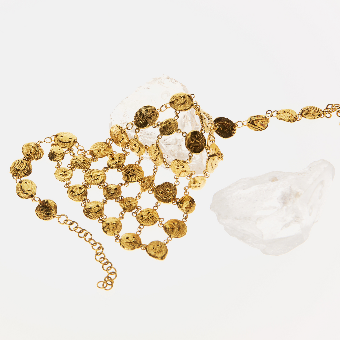 Contemporary artisan gold necklace styled with natural crystal