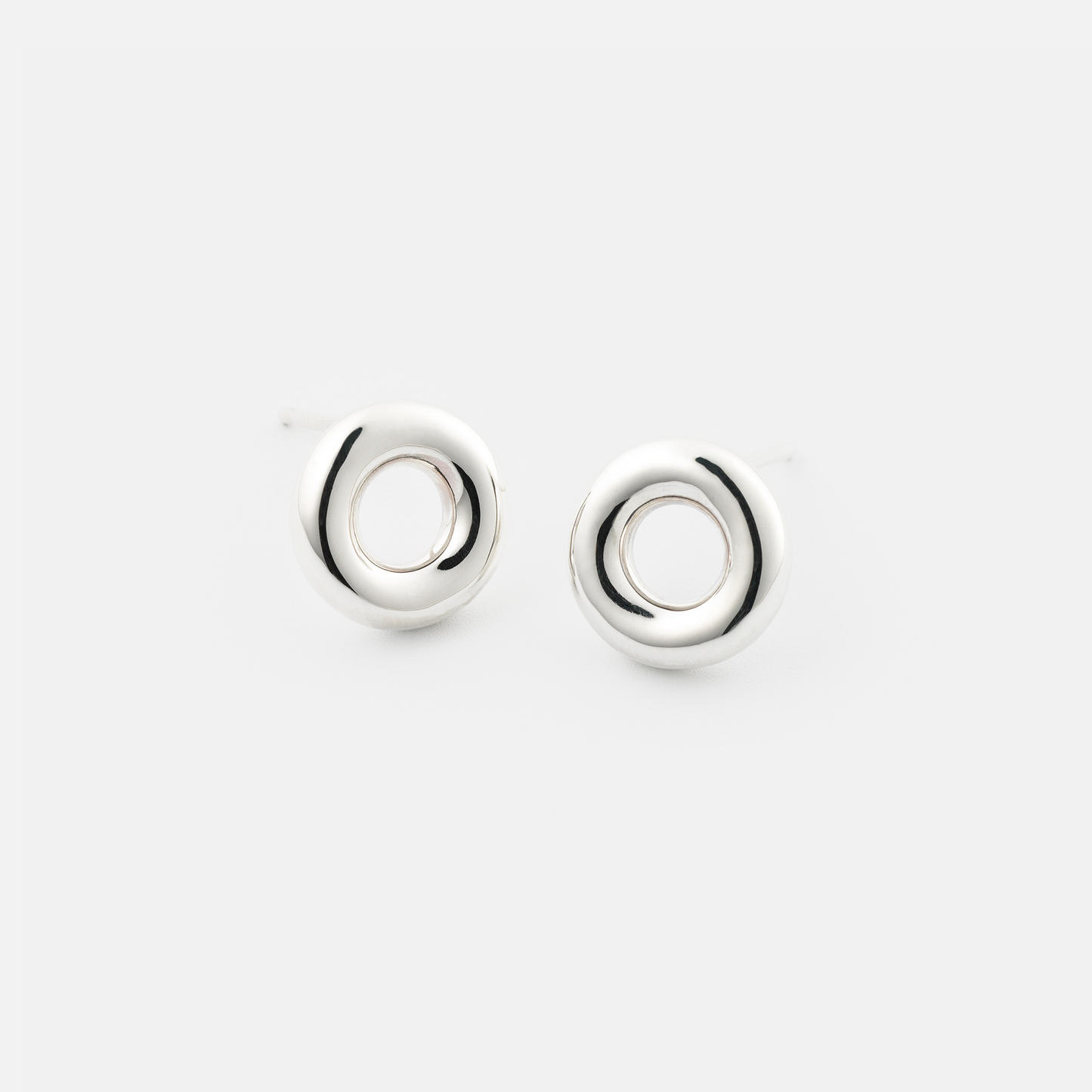 Pair of silver circular earrings on a white background
