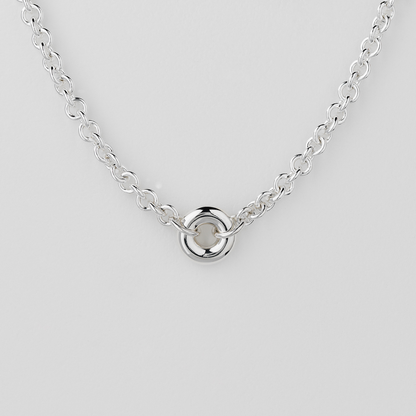 Close-up of the Monad Sterling Silver Chain Necklace with a polished torus link on a handcrafted sterling silver cable chain.