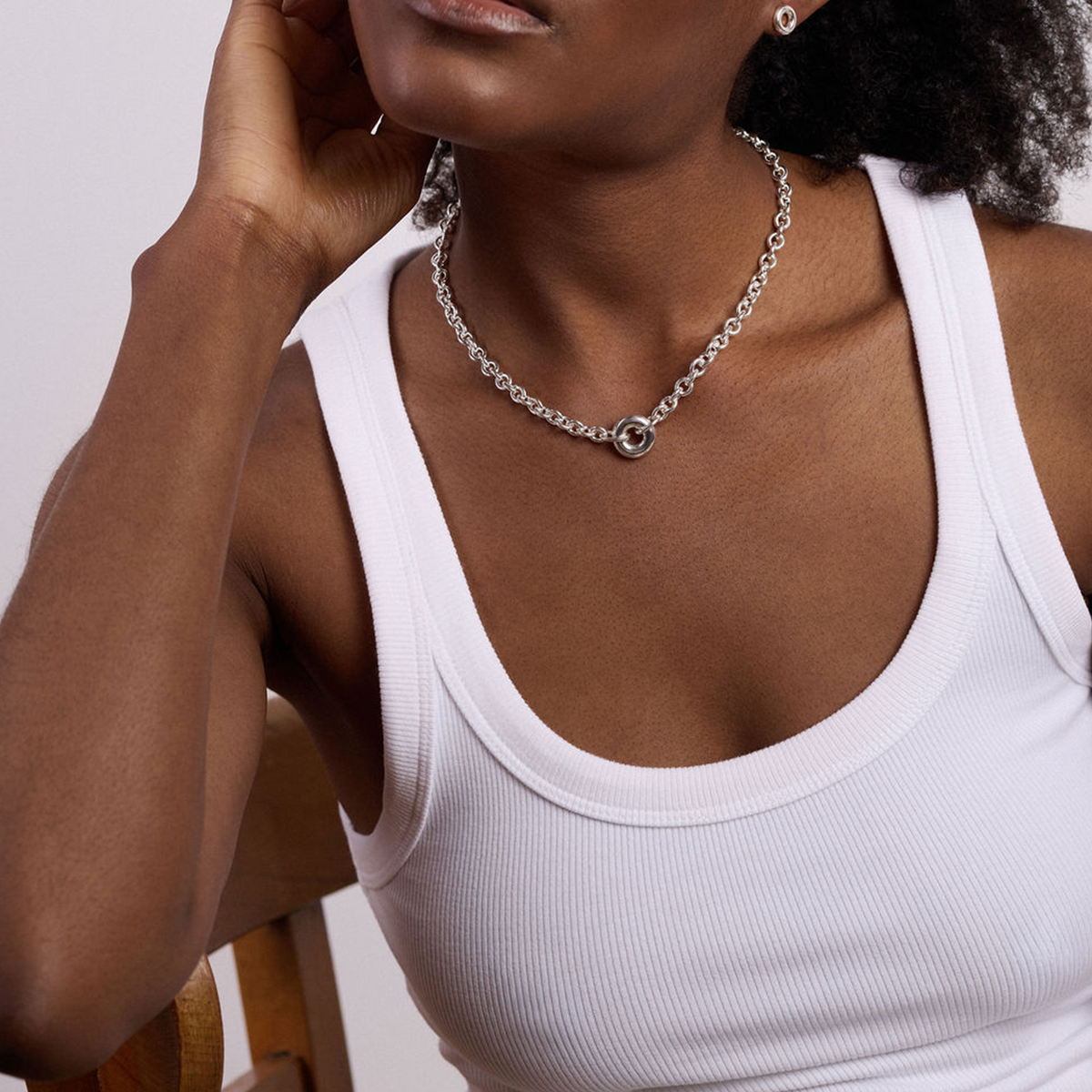 Close-up of the Monad Sterling Silver Chain Necklace worn by model, highlighting the polished torus centrepiece and handcrafted sterling silver chain.