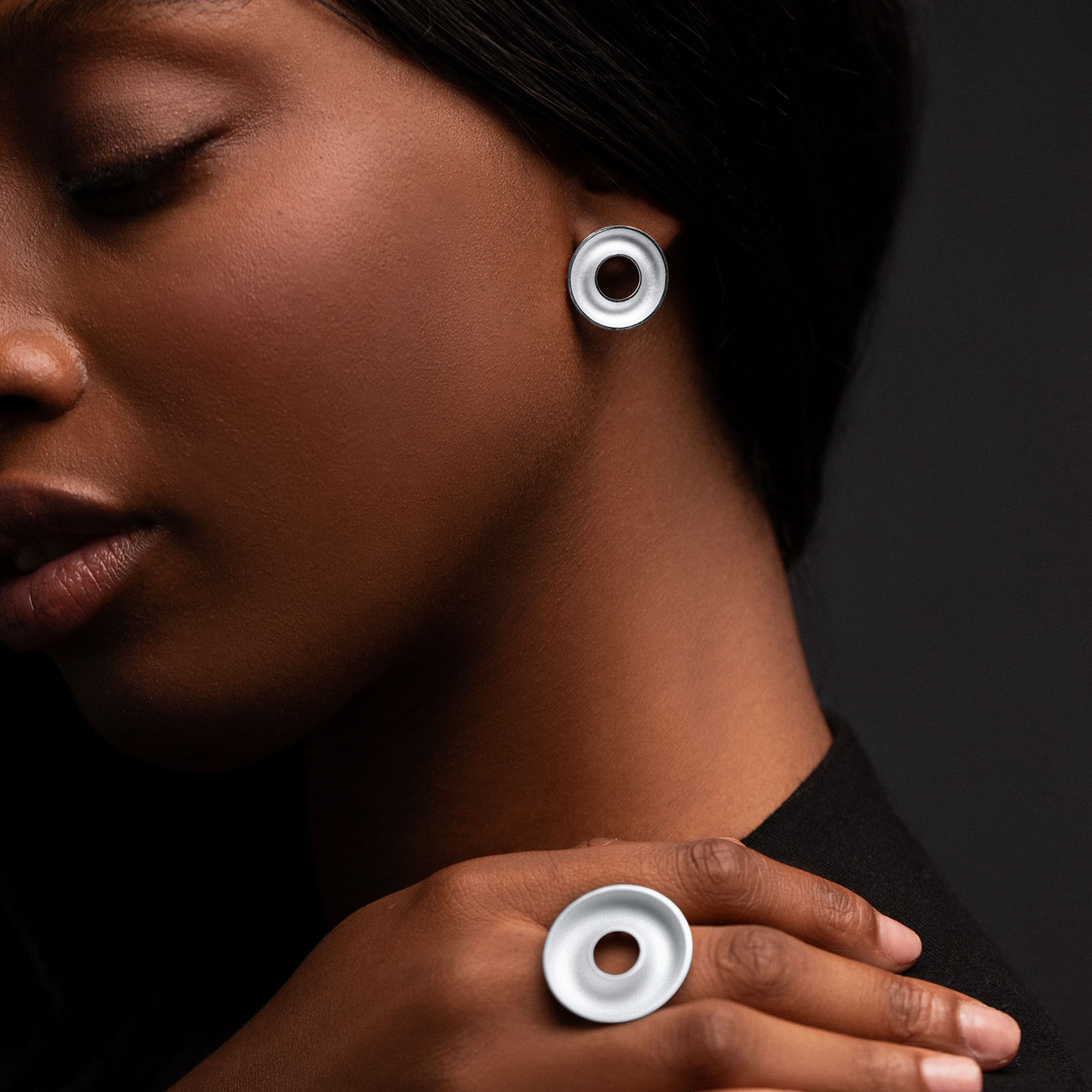 Model wearing Orbis Medium Sterling Silver Stud Earrings with a sculptural concave torus design. Handmade contemporary sterling silver jewellery.