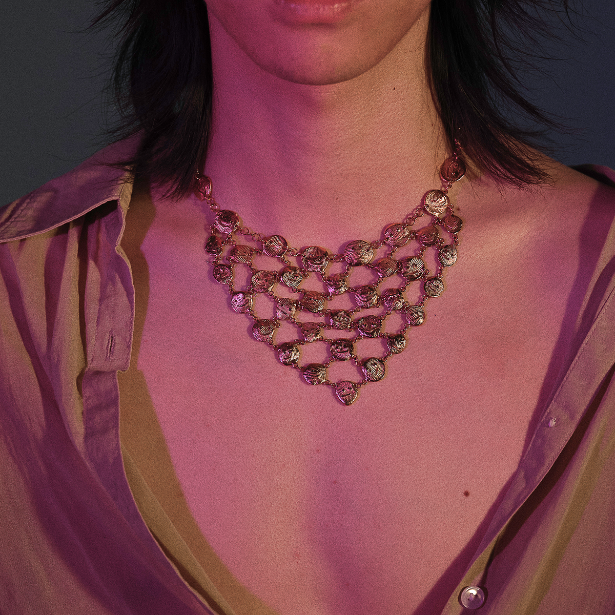 Contemporary gold sculptural necklace styled for evening wear