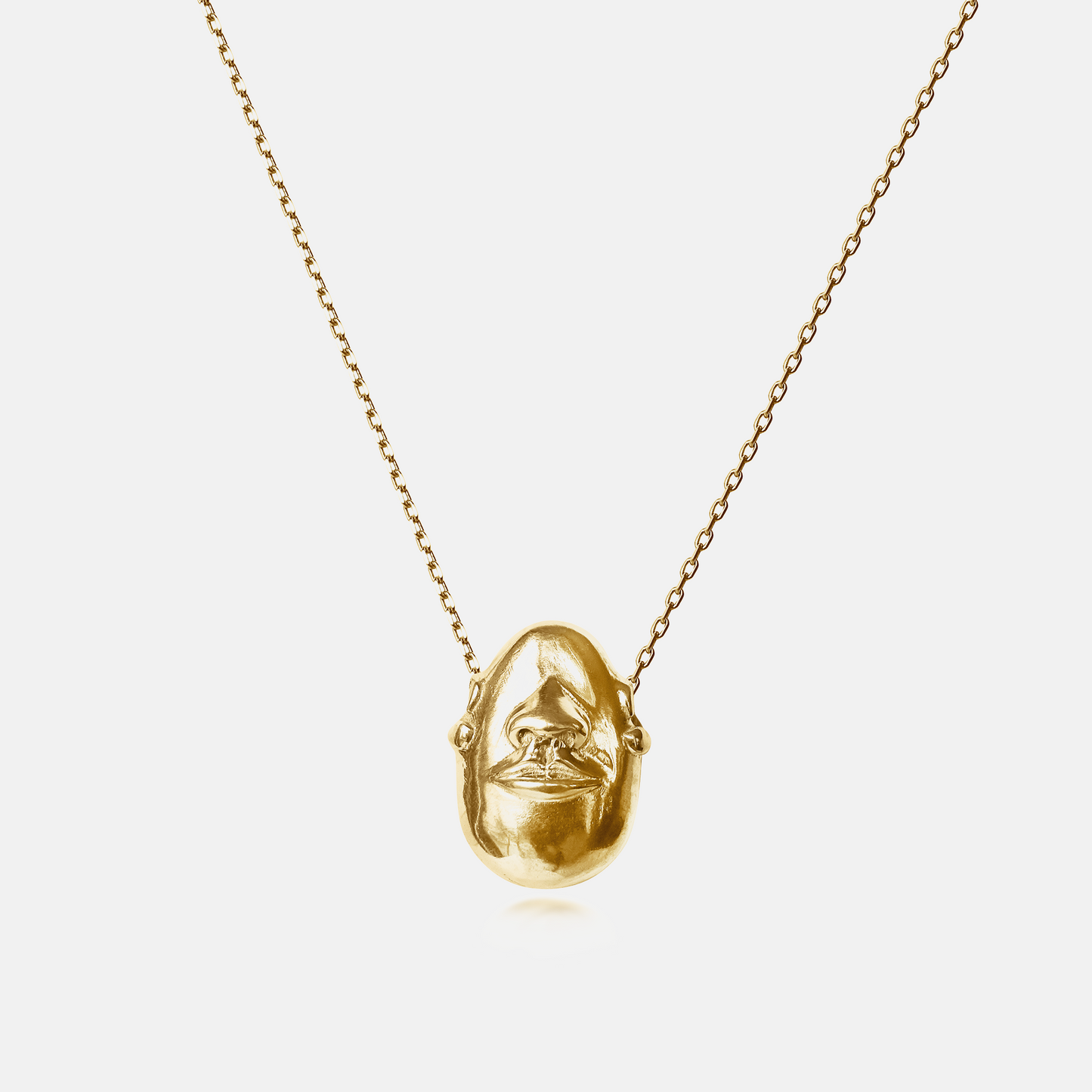 Hear No Evil Pendant Necklace in gold with a sculptural face motif on a delicate chain