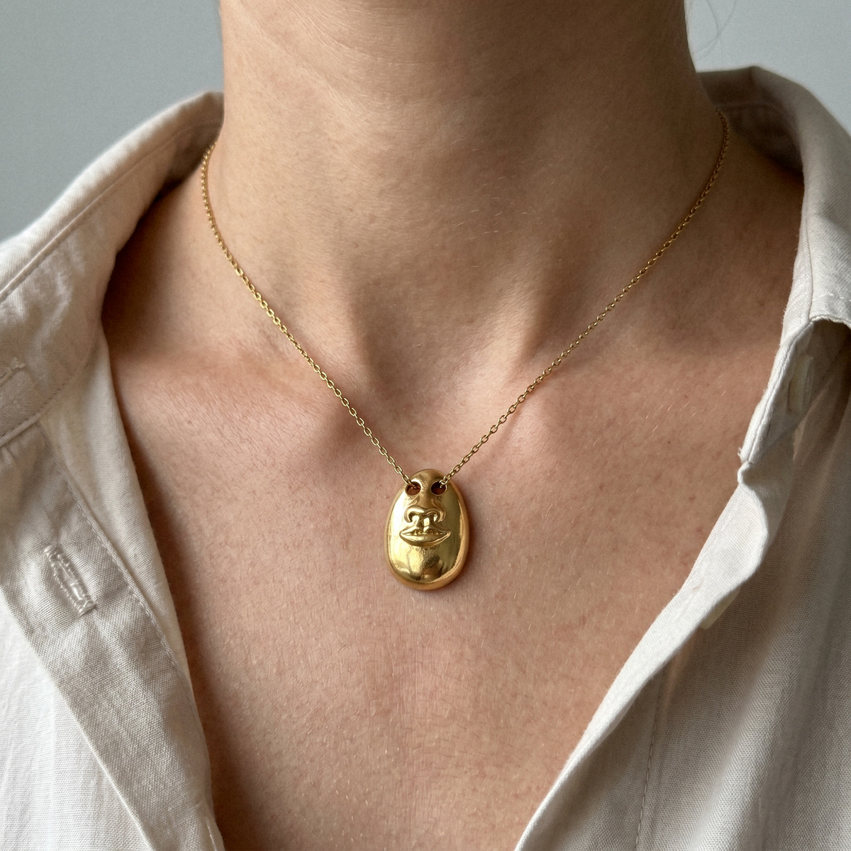 Model wearing the Hear No Evil gold pendant necklace on a fine chain
