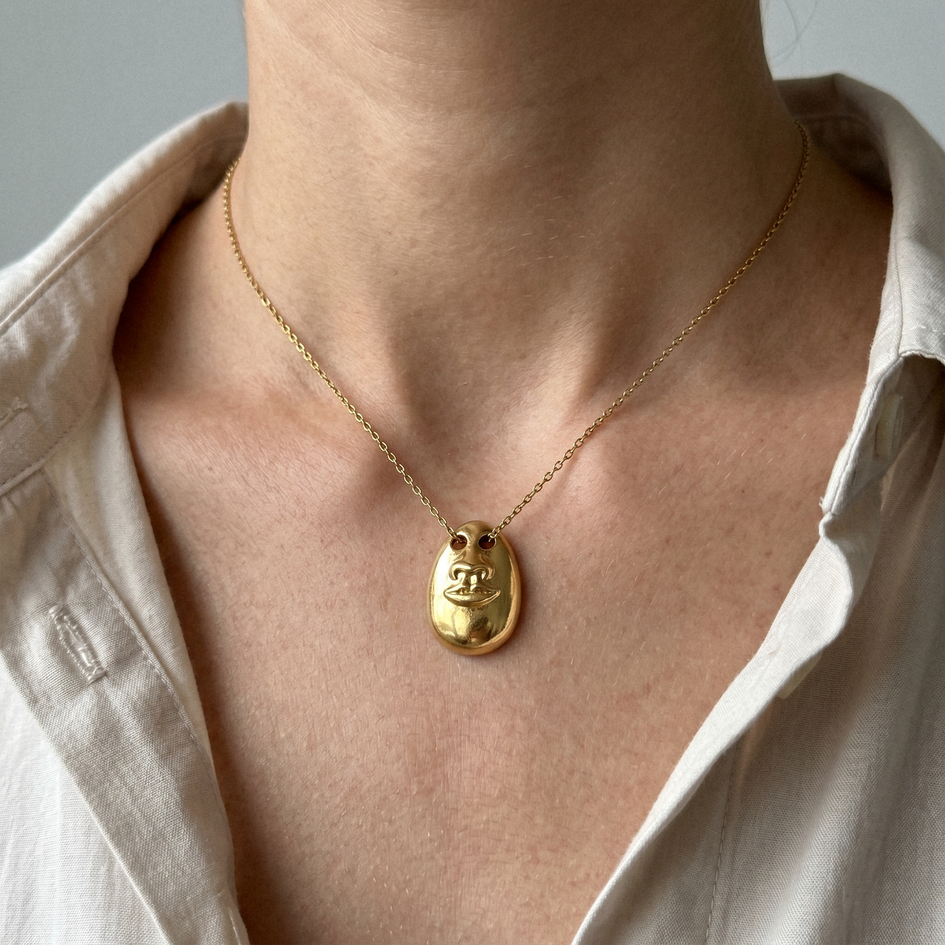Model wearing the Hear No Evil gold pendant necklace on a fine chain
