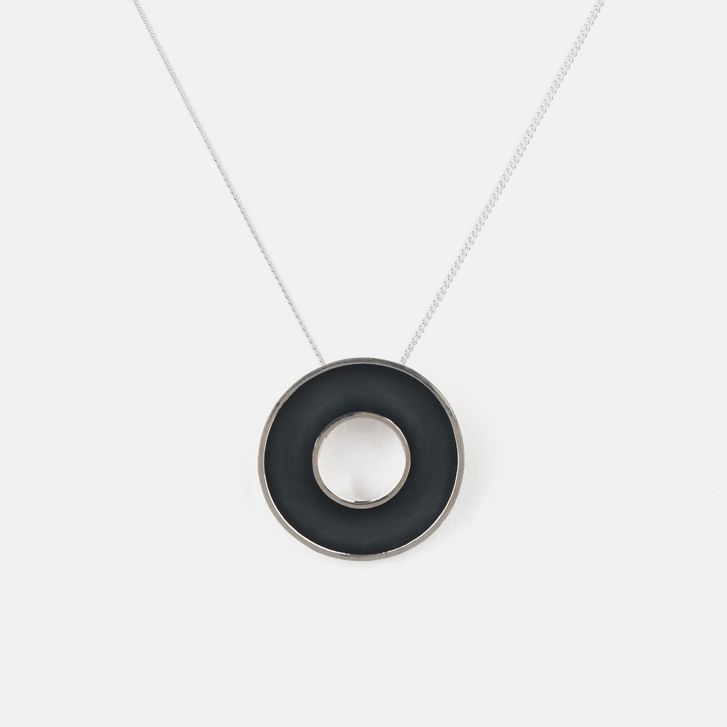 Necklace with a black circular pendant on a white background