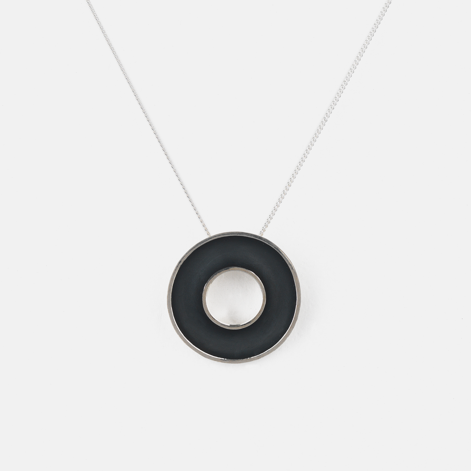 Necklace with a black circular pendant on a white background