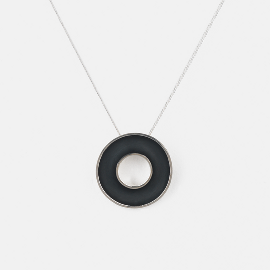 Necklace with a black circular pendant on a white background