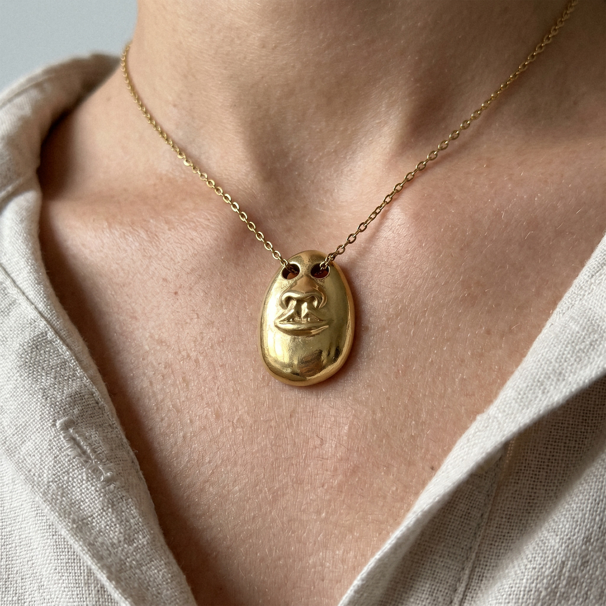 Close-up of the See No Evil gold pendant necklace featuring a sculptural face motif on a fine chain.