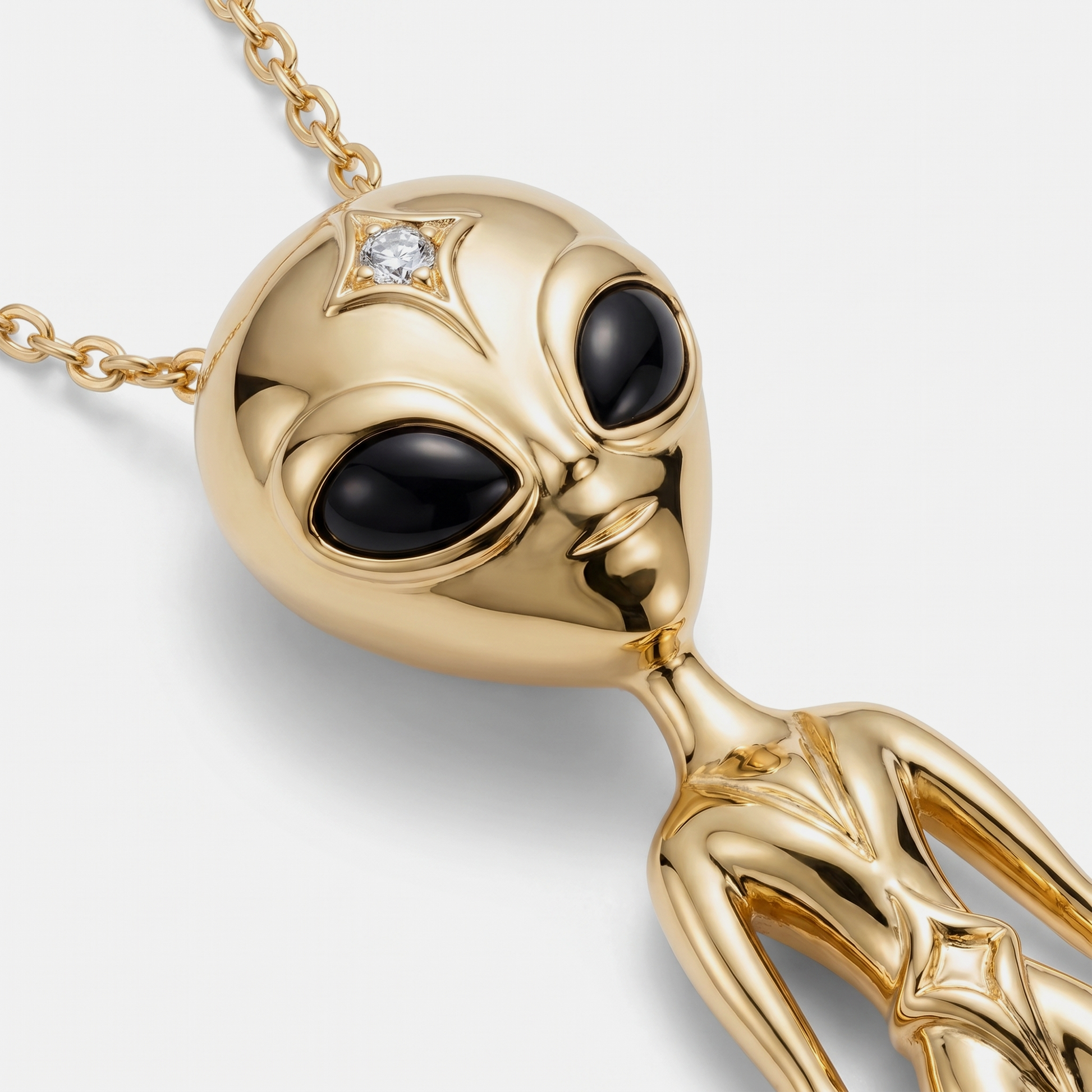 Close-up alien pendant in 18k gold with black enamel eyes and diamond detail, luxury jewellery craftsmanship