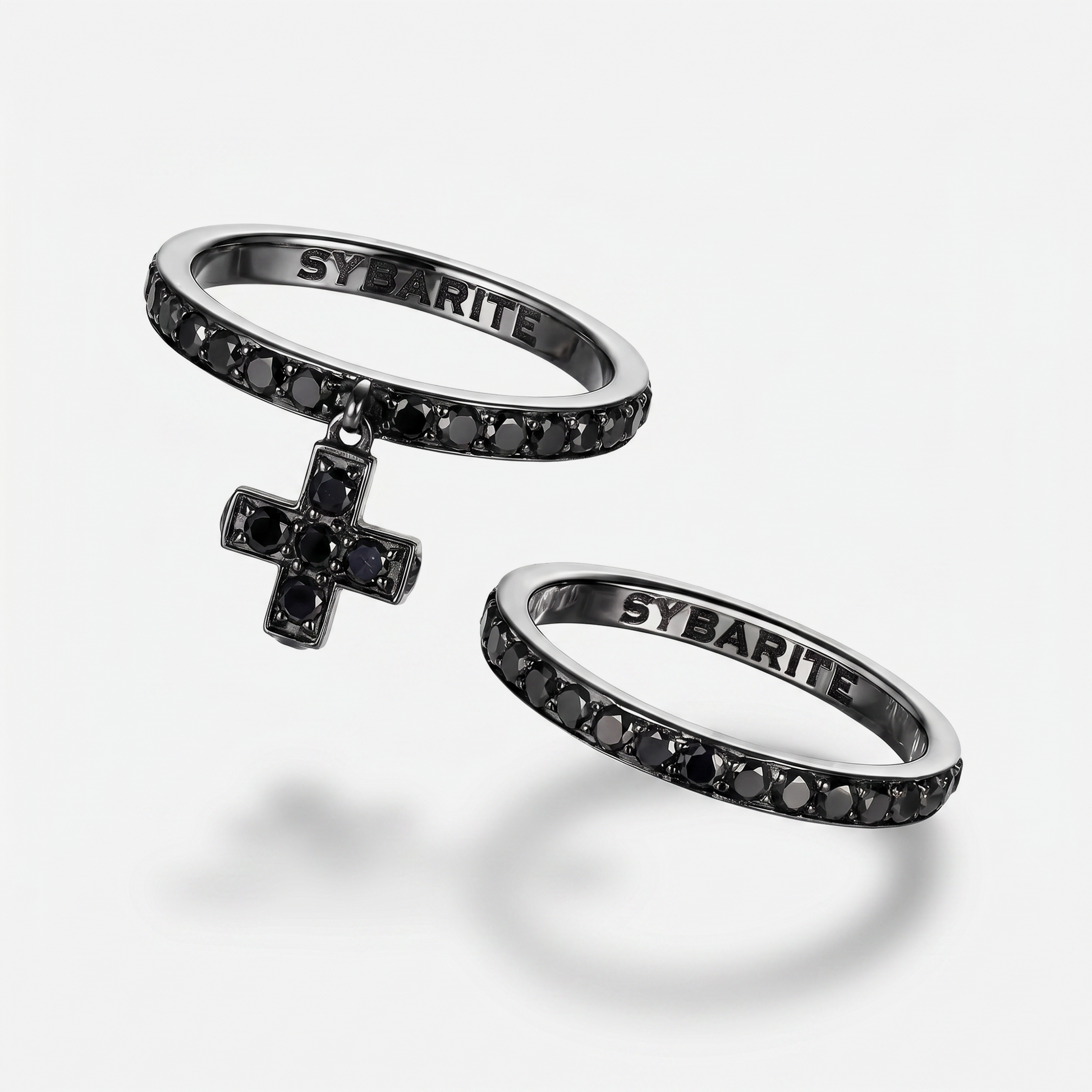 Blackened 18k gold rings set with black diamonds by Sybarite Jewellery, luxury designer stackable rings with cross charm, modern gothic fine jewellery