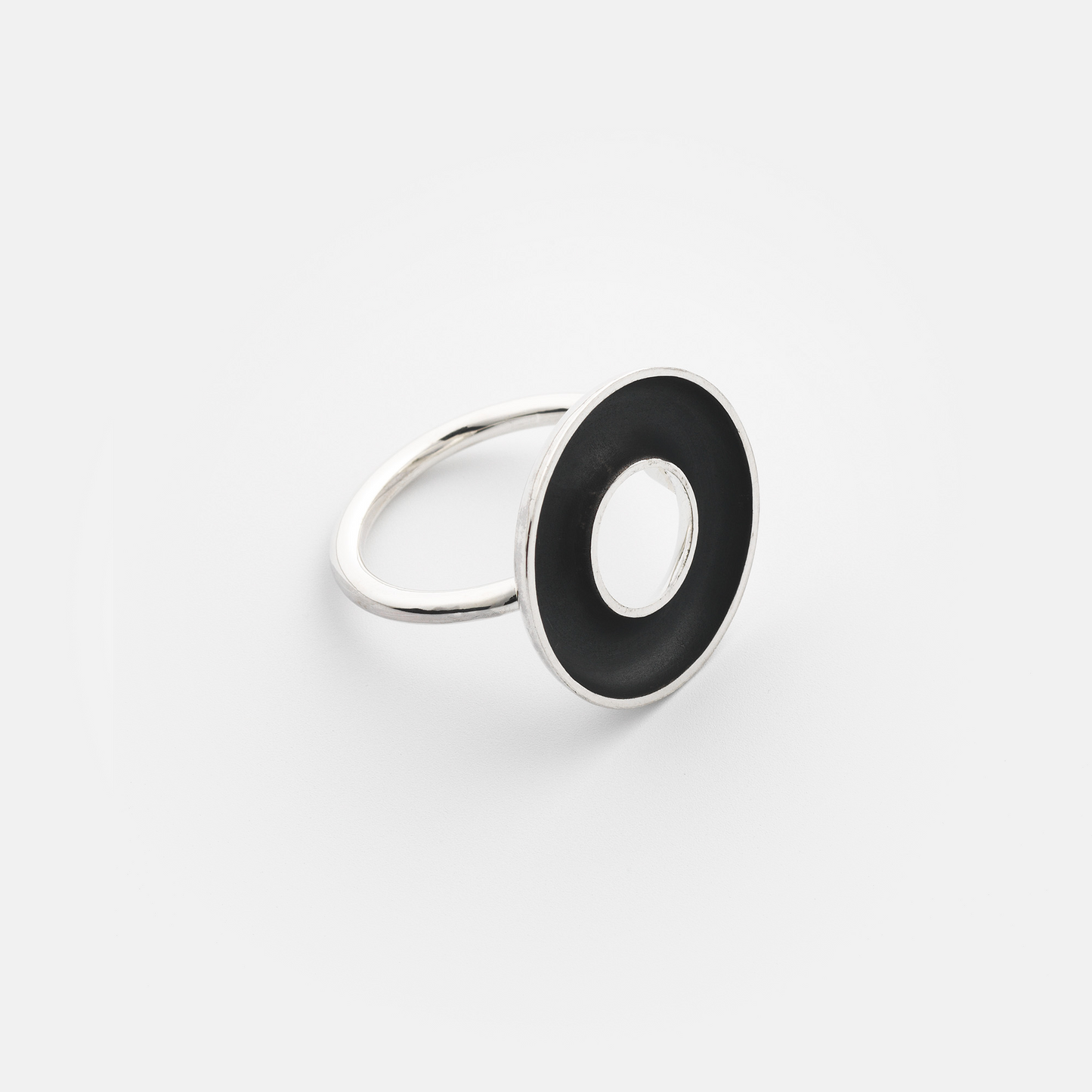 Silver ring with a black circular inset on a white background