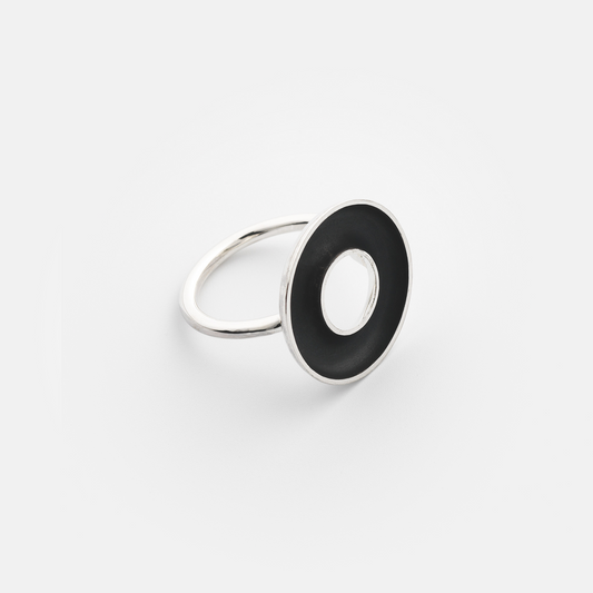 Silver ring with a black circular inset on a white background