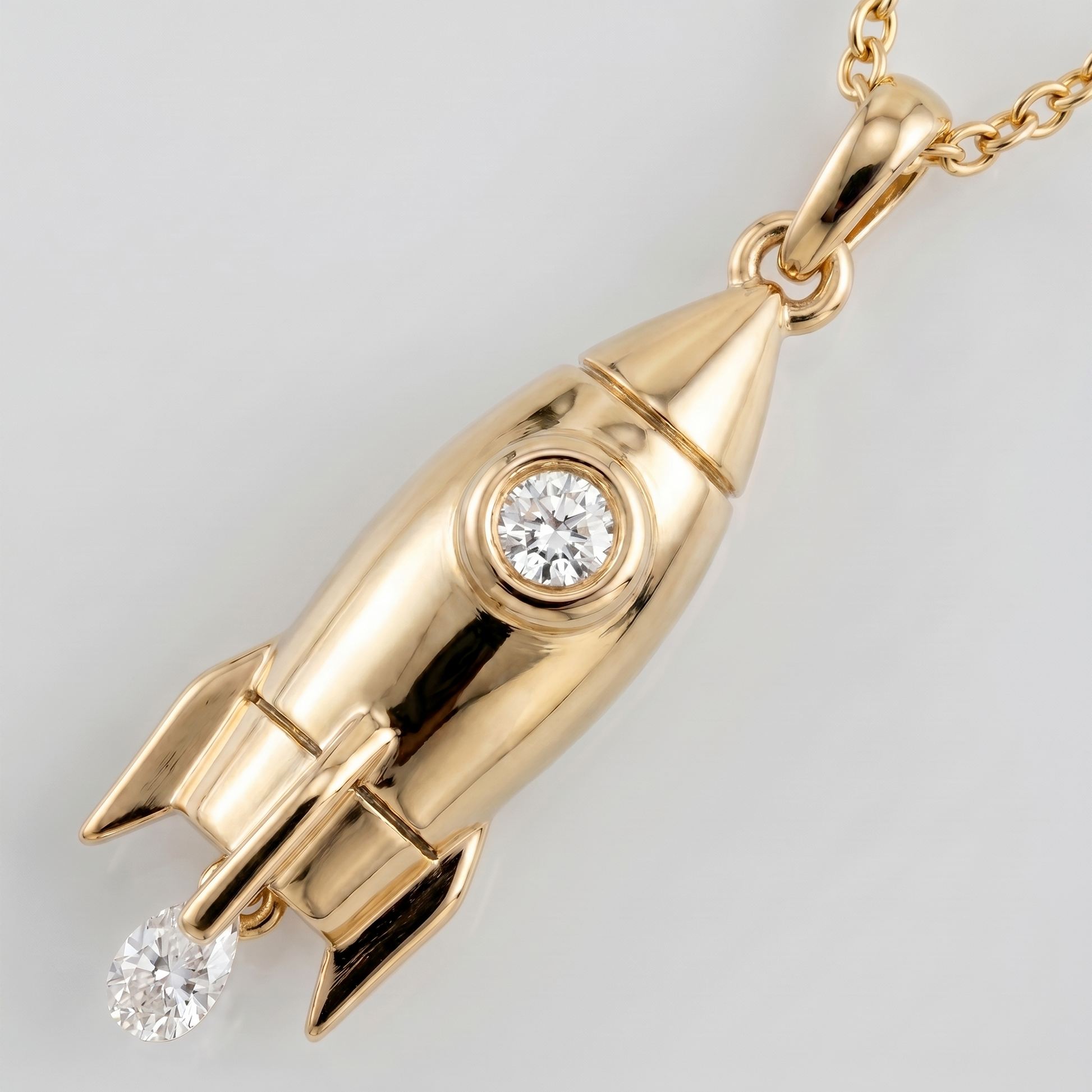 Close-up gold rocket pendant with diamond in 18k yellow gold, fine jewellery detail with celestial inspiration