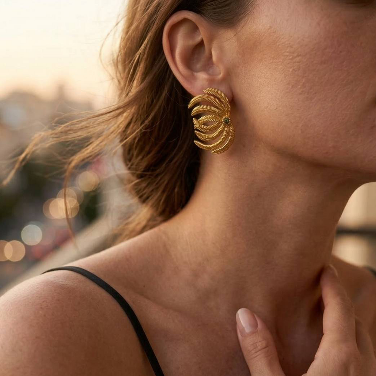 Model wearing sculptural palm leaf earrings