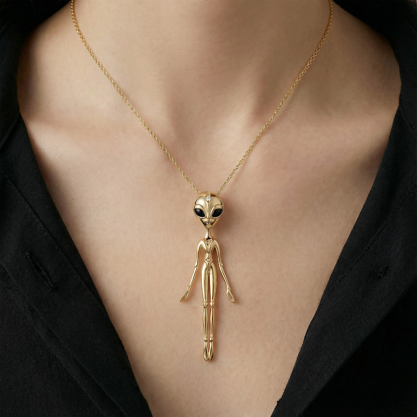 Gold alien pendant necklace in 18k yellow gold on model, bold celestial luxury jewellery styling