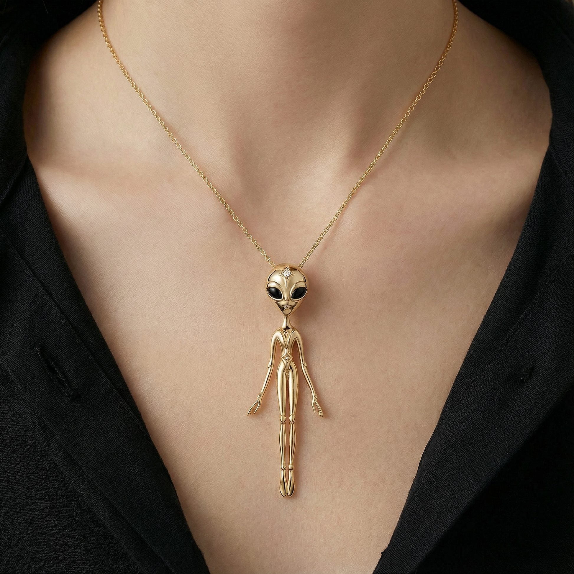Gold alien pendant necklace in 18k yellow gold on model, bold celestial luxury jewellery styling