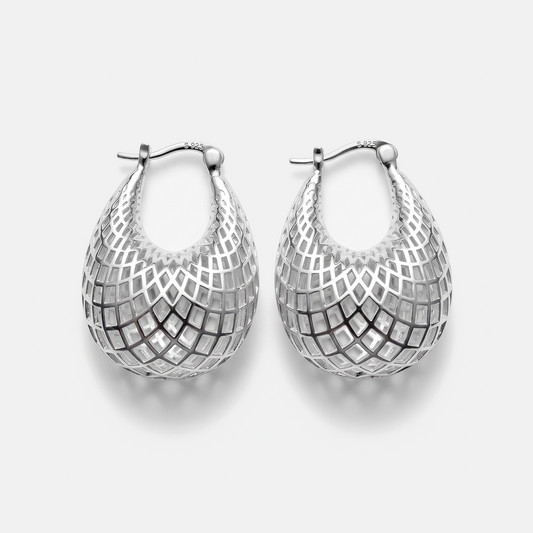 A pair of silver teardrop-shaped hoop earrings with a geometric openwork mesh pattern, displayed on a light gray background.