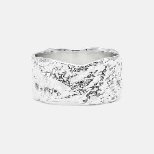 Silver ring with a textured surface on a white background
