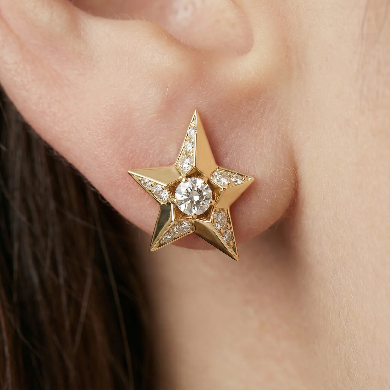 Close-up diamond star earrings in 18k yellow gold, fine jewellery detail luxury design