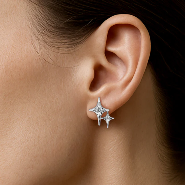 White gold diamond star earrings worn on ear, delicate everyday fine jewellery look
