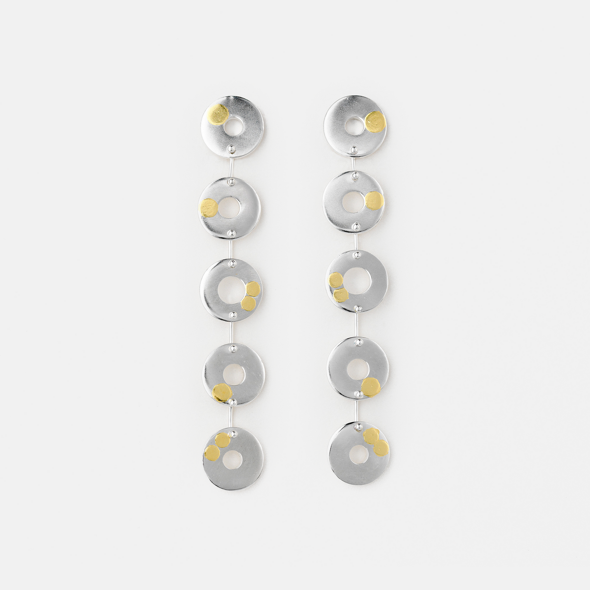 Pair of silver earrings with circular designs on a white background