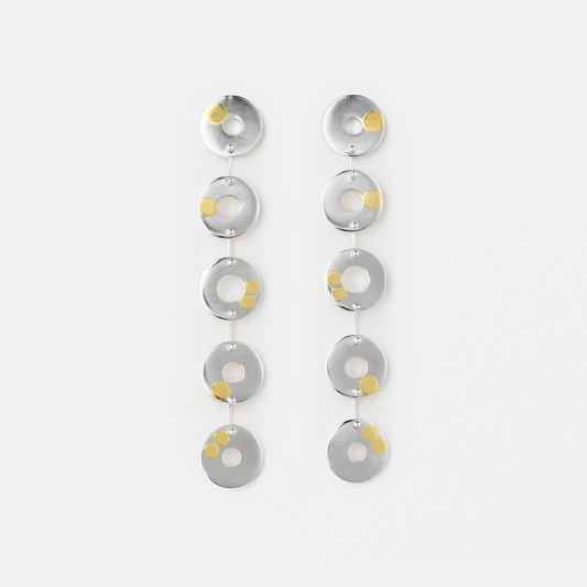 Pair of silver earrings with circular designs on a white background