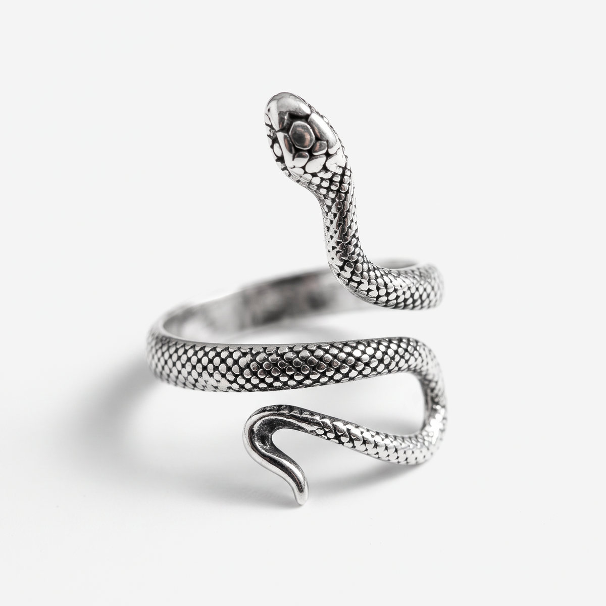 A silver snake ring with a detailed textured scale pattern, featuring a raised snake head and a coiled body, photographed on a clean white background.