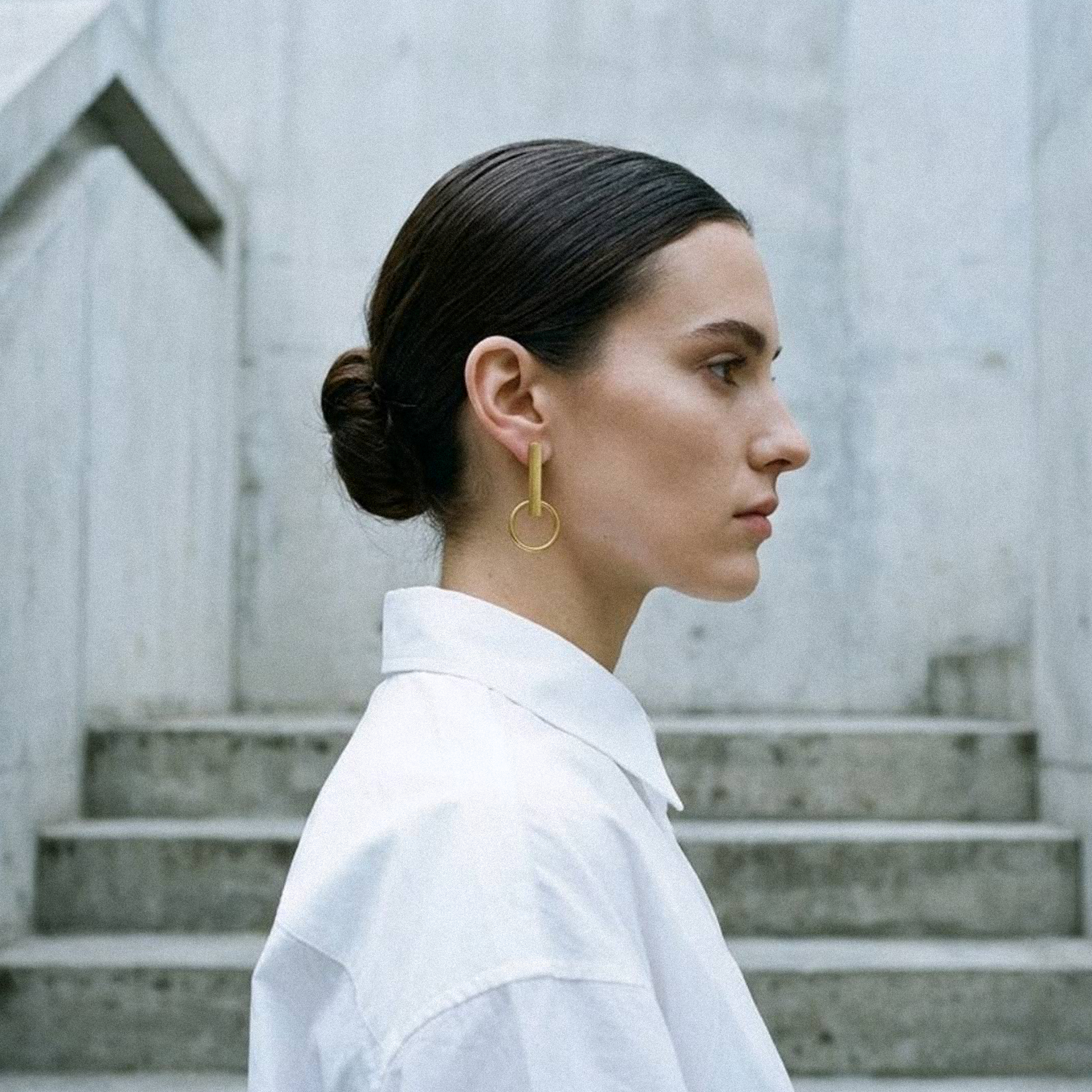 Model wearing Orbit gold statement earrings