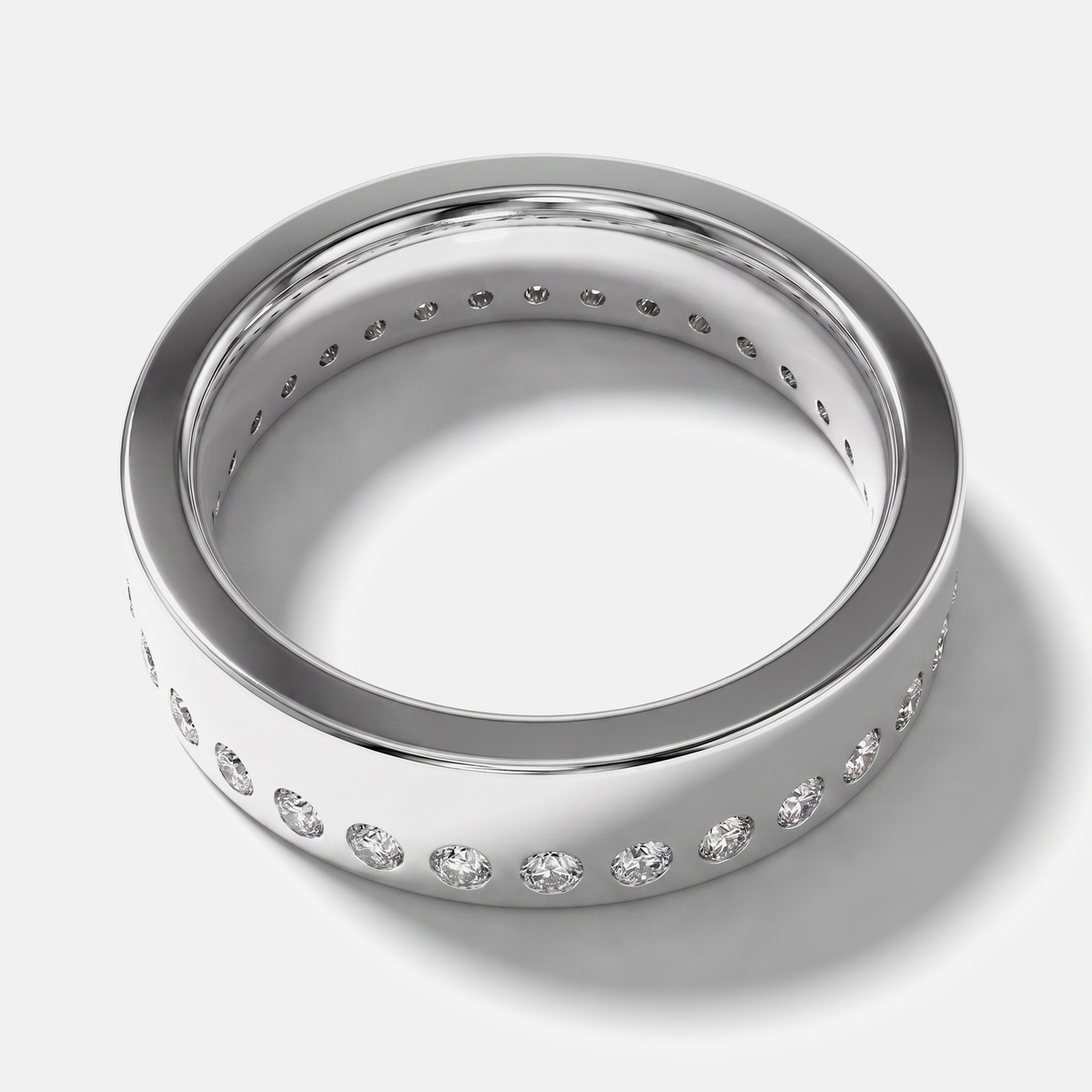 A polished silver-toned eternity ring featuring a row of round-cut clear gemstones set around the band, shown on a clean light gray background.