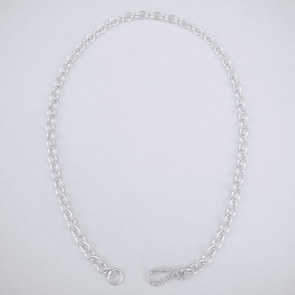 Silver chain necklace on a light gray background