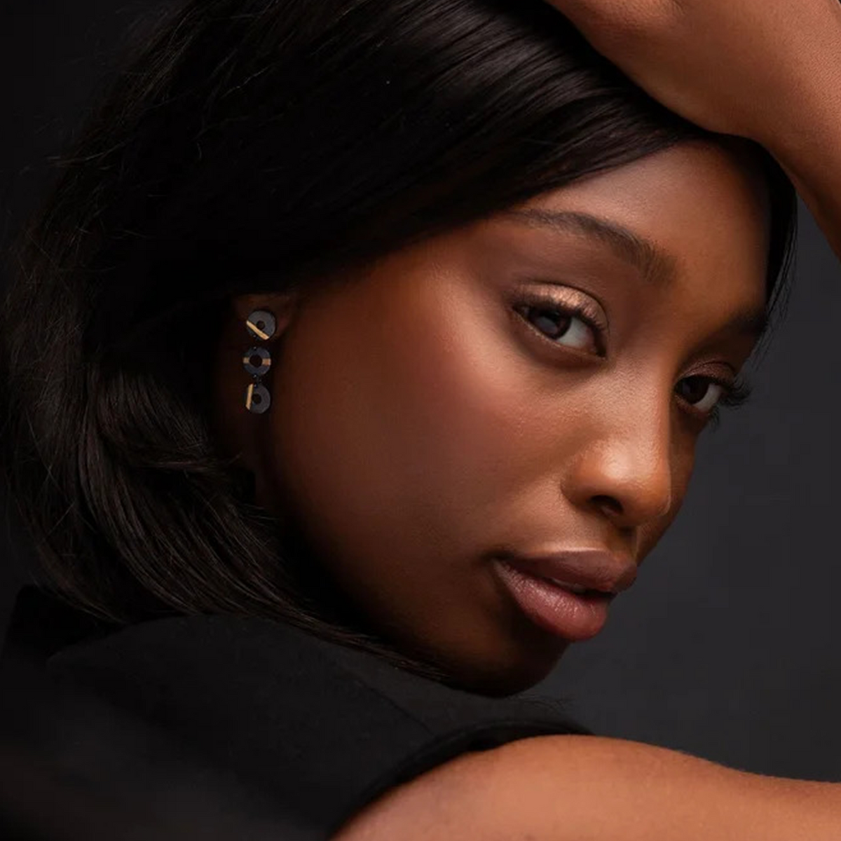 Woman with a serious expression against a dark background