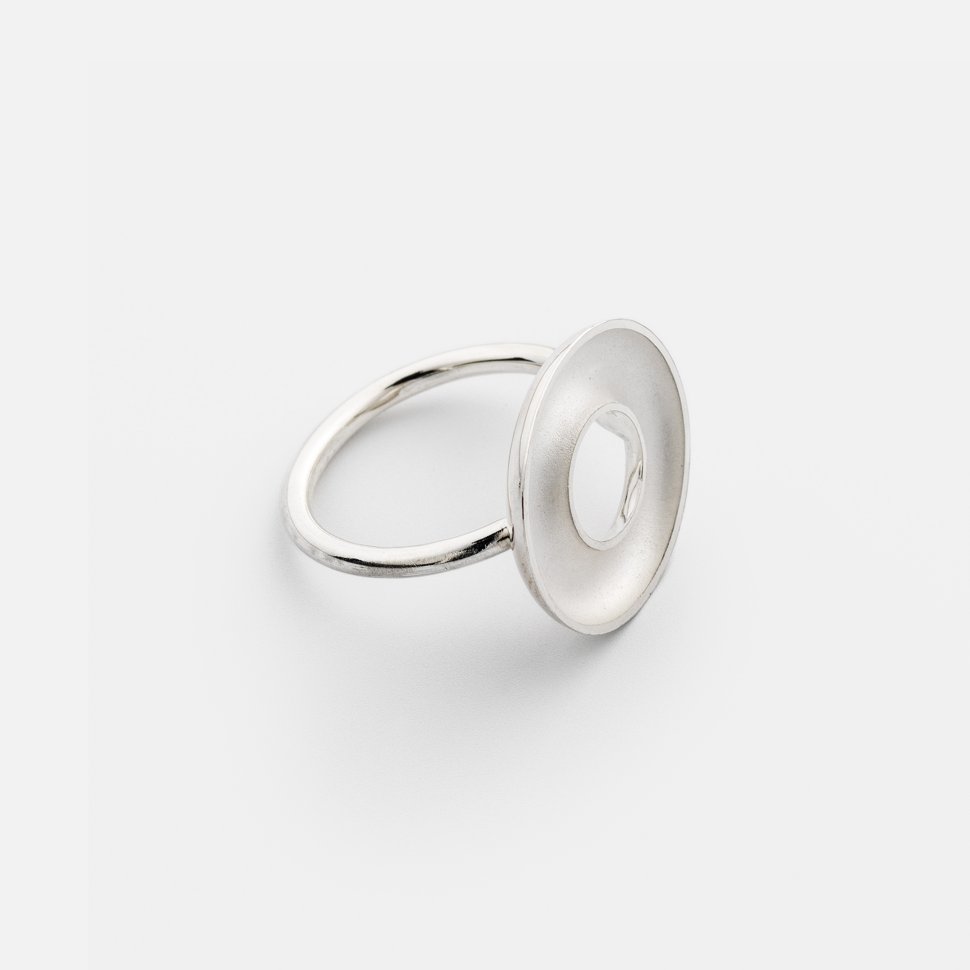 Silver ring with a circular design on a white background