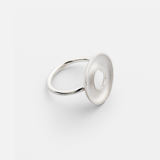 Silver ring with a circular design on a white background