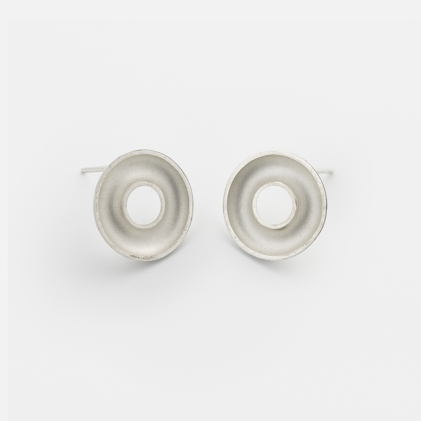 Handmade Orbis Small Sterling Silver Stud Earrings featuring a sculptural concave torus design with polished finish. Contemporary minimalist jewellery handcrafted in Glasgow.