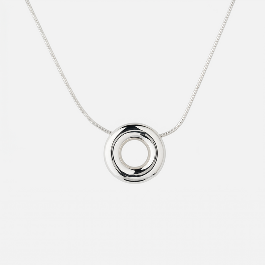 Handmade Monad Medium Sterling Silver Necklace featuring a polished 20 mm hollow torus pendant on a sterling silver snake chain. Contemporary designer jewellery handcrafted in Glasgow.