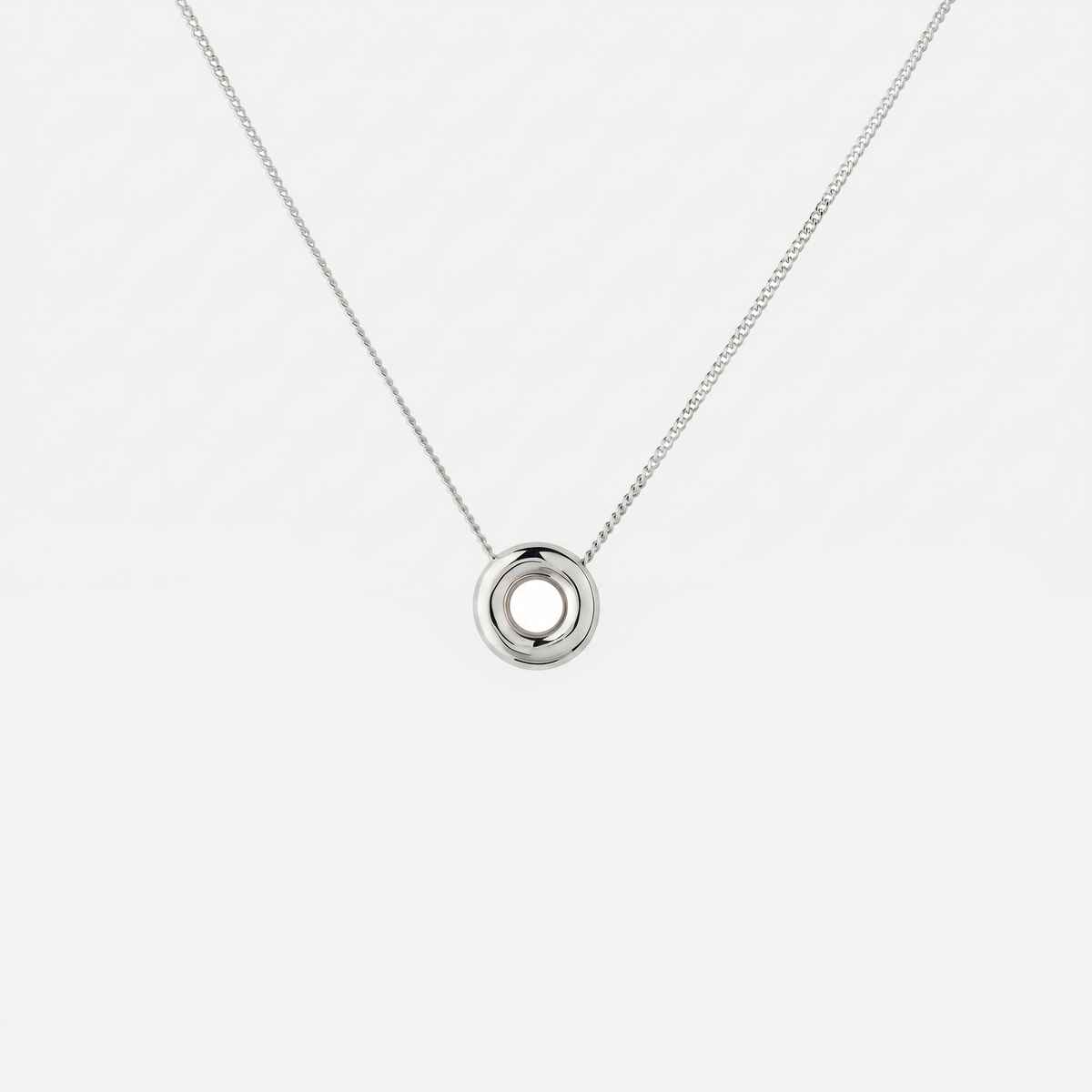 Handmade Monad Mini Sterling Silver Necklace featuring a polished 10 mm torus pendant on a fine sterling silver curb chain. Contemporary minimalist jewellery handcrafted in Glasgow.