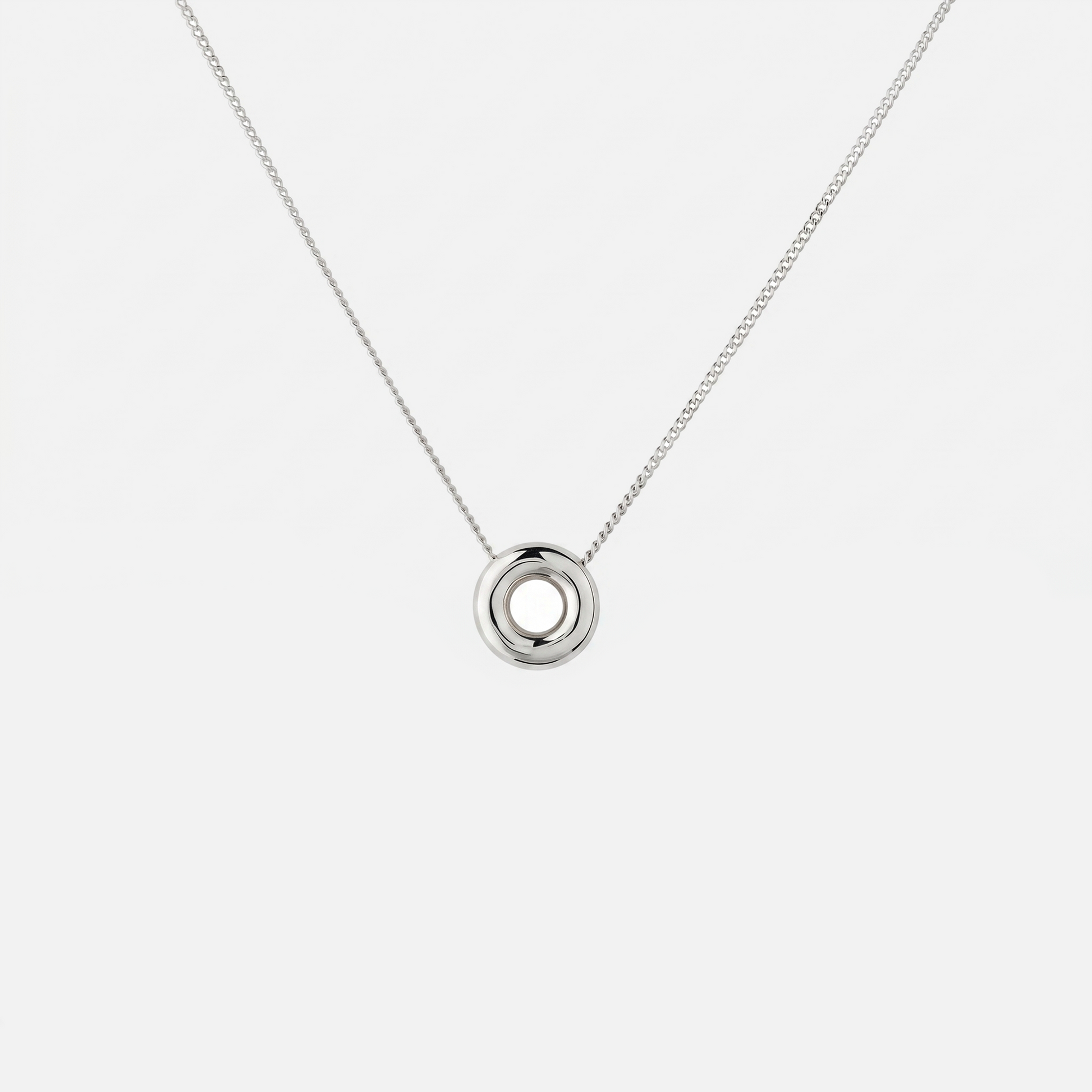 Handmade Monad Mini Sterling Silver Necklace featuring a polished 10 mm torus pendant on a fine sterling silver curb chain. Contemporary minimalist jewellery handcrafted in Glasgow.