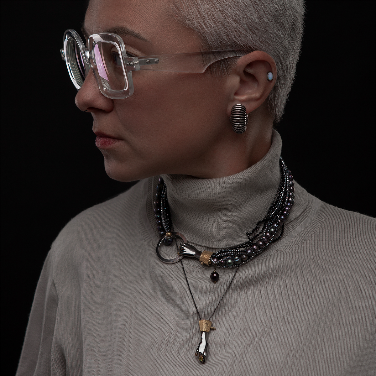 Layered luxury necklaces with black hand pendant, pearls and gold details, designer statement jewellery styling