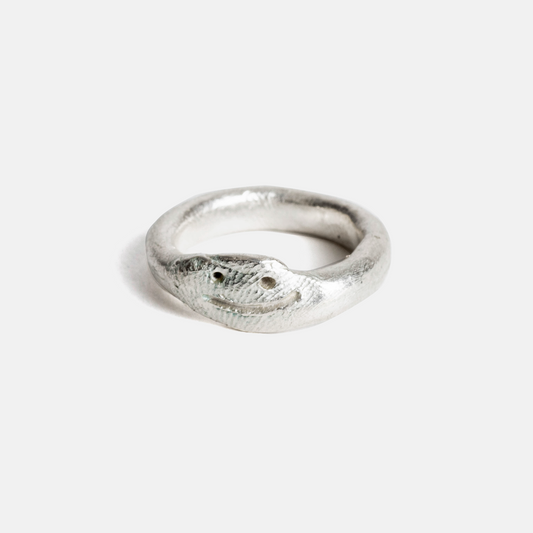 Silver ring with a textured surface on a white background