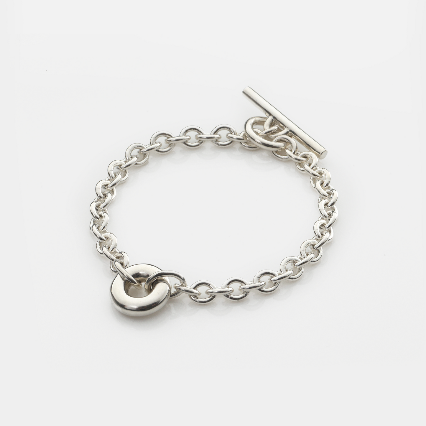 Handmade sterling silver Monad Chain Bracelet featuring a sculptural polished torus link, chunky cable chain and T-bar clasp. Contemporary designer jewellery handcrafted in Glasgow.
