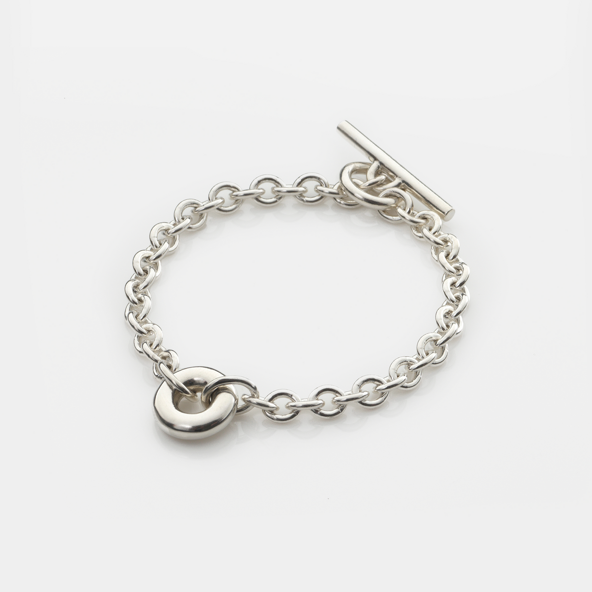 Handmade sterling silver Monad Chain Bracelet featuring a sculptural polished torus link, chunky cable chain and T-bar clasp. Contemporary designer jewellery handcrafted in Glasgow.