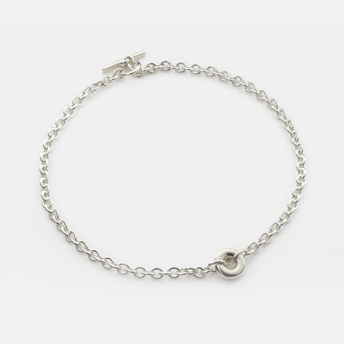 Handmade sterling silver Monad Chain Necklace featuring a polished sculptural torus pendant, chunky cable chain and T-bar clasp. Contemporary designer jewellery handcrafted in Glasgow.