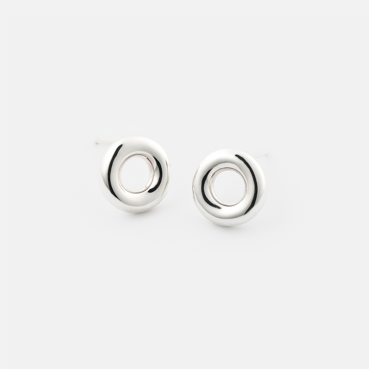 Pair of silver circular earrings on a white background