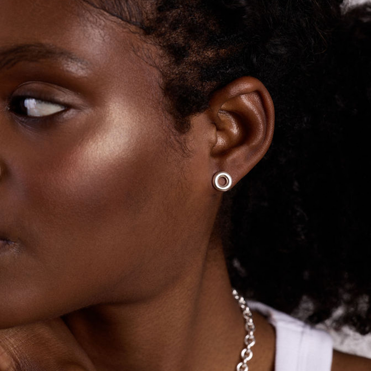 Pair of silver circular earrings on a white background