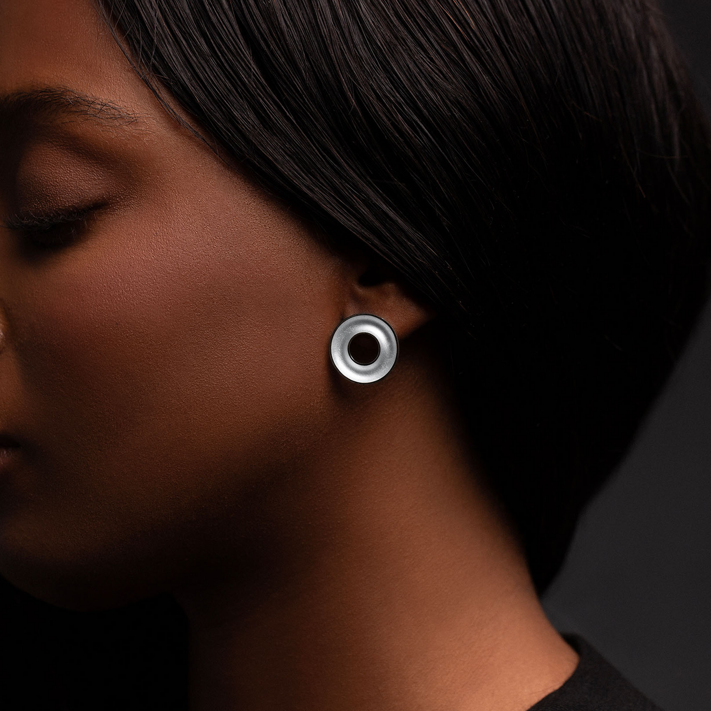 Close-up of handcrafted Orbis Medium Sterling Silver Stud Earrings worn by model, showcasing the polished 20 mm concave torus design.